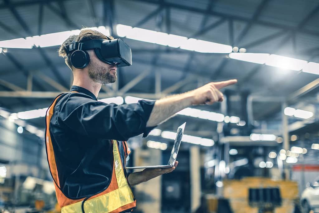 Engineer male using VR virtual reality technology in modern ware